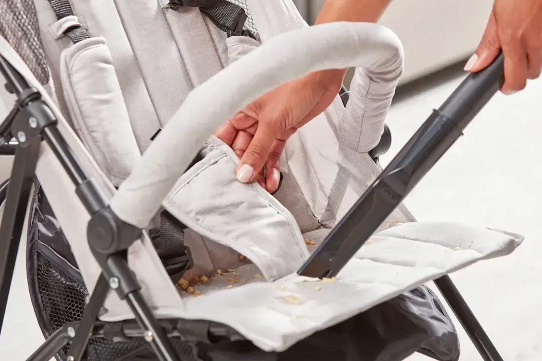 Dùng máy hút bụi để hút sạch vụn đồ ăn và bụi bẩn trong xe đẩy trước khi giặt